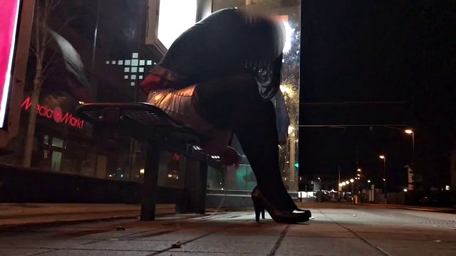 Crossdresser fixed on a bench in a tram station