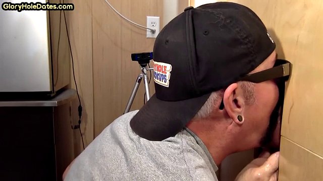 Gray DILF sucks and jerks dick at glory hole until she cums