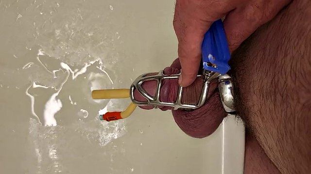 Pissing with a catheter locked in a chastity cage