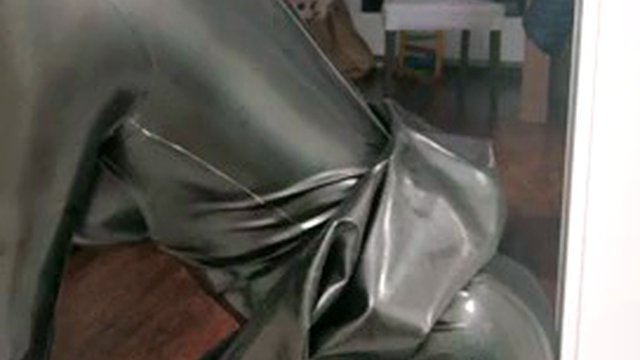 Rubber latex sissy in gas mask plays with a dildo